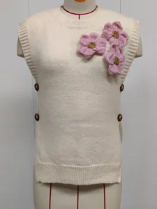 Detalle chaleco punto beige, jersey sin mangas con flores rosa 3D y botones laterales.