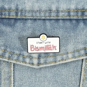 Detailaufnahme einer rechteckigen Bismillah Emaille-Anstecknadel auf Denim-Hintergrund