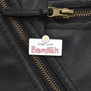 Nahaufnahme einer weißen Bismillah-Emaille-Anstecknadel auf einer schwarzen Lederjacke