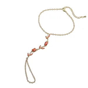 Détail d'une chaîne de main tulipe dorée avec des pierres de cristal orange vif