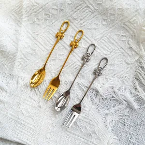 Elegantes Besteckset aus Gold und Silber mit Schleife und Diamant-Details aus Stahl.