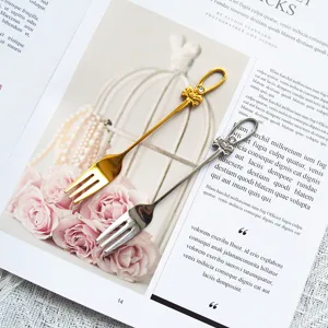 Elegante Edelstahl-Dessertgabeln mit Schleifen- und Kristalldetail auf einem Magazin