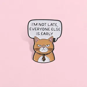 Detalle de pin de gato naranja con mensaje divertido I'M NOT LATE sobre el fondo