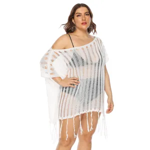 Detailed view of white hollow-out knit beach cover-up with stylish fringe hemline