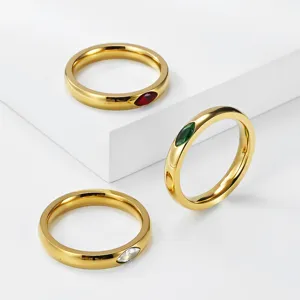 Detailed view of 18K gold plated rings with red, green, and white marquise gemstones.