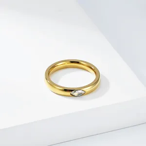 Detailed close-up of gold-plated titanium steel ring with marquise-cut gemstone inlay.