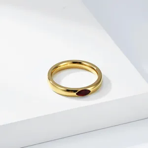 Detailed view of polished gold titanium steel ring with a marquise red gemstone inlay