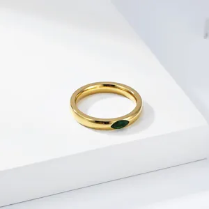 Macro view of a luxury titanium steel gold-plated ring with green marquise gemstone