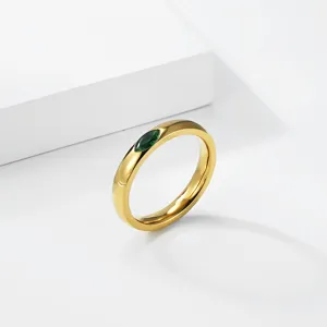 Close-up of a 18K gold plated titanium steel ring with a marquise green gemstone inlay.