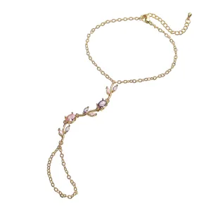 Gros plan détaillé sur la parure de main dorée avec motif tulipe en zircon rose.