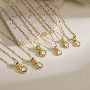Detail view of gold plated necklaces with heart, pear, and round zircon pendants.