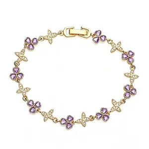 Detail of gold-plated bracelet with purple heart clovers and sparkling CZ butterflies