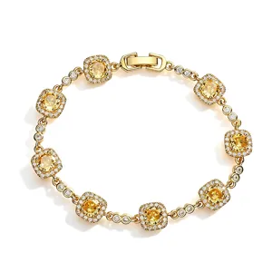 Close-up detail of a gold-plated bracelet with yellow cushion-cut crystals and micro-pavé
