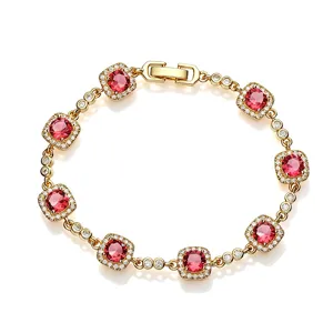 Detailed view of gold-plated bracelet with radiant cushion-cut red gemstones