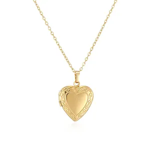 Vintage gold heart locket necklace with elegant scroll engraving detail on white background