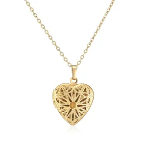 Detailed view of a gold vintage heart locket necklace with intricate sunburst pattern.