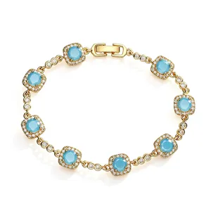 Close-up of golden bracelet with square-cut blue stones and sparkling zircon halo.