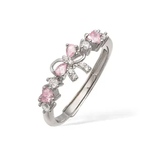 Dettaglio di un anello elegante in argento con fiocco in cristallo rosa e cuori.