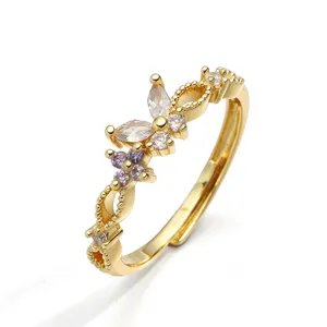 Dettaglio ravvicinato dell'anello regolabile placcato oro con motivi a farfalla e fiori