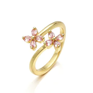 Vista dettagliata dell'anello aperto placcato oro con due ciondoli a fiore rosa