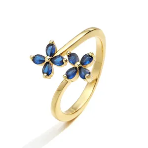 Dettaglio dell'anello regolabile dorato con due fiori di pietre blu marquise