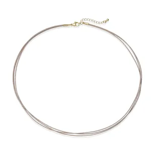 Detailed view of the three-layer woven necklace with golden lobster clasp and extender chain.