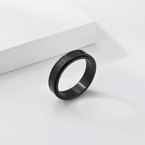 Gros plan d'une bague en acier titane noir avec incrustation en fibre de carbone