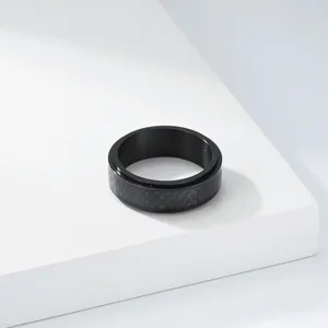 Gros plan d'une bague rotative en acier titane noir avec incrustation en fibre de carbone