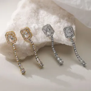 Dettaglio di eleganti orecchini a nappine con zirconi cubici in finitura oro e argento