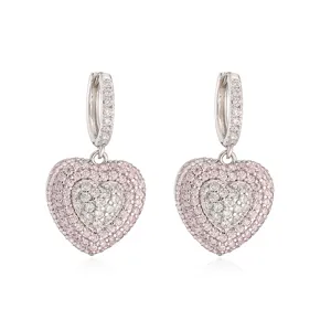 Close-up of delicate double-layer heart earrings encrusted with pink and white crystals