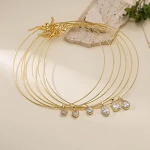 Close-up of gold stainless steel chokers with various geometric cubic zirconia pendants