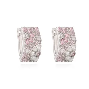 Detailopname van prachtige zilverkleurige oorringen met roze en witte bloemkristallen.