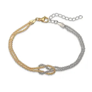 Dettaglio del bracciale a nodo d'amore bicolore intrecciato con catene a maglia stellata