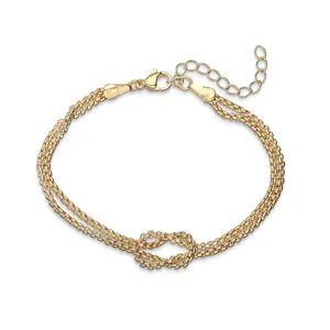 Dettaglio di un bracciale a doppio filo placcato in oro con design a nodo infinito vintage.
