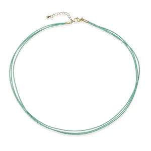Detailed view of a triple-layer mint green hand-woven cord necklace with gold hardware
