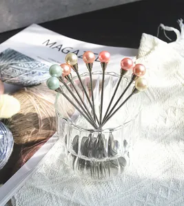 Elegante Detailansicht von Edelstahl-Dessertgabeln mit Perlenverzierung in Glas