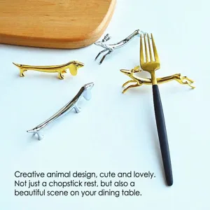 Macro view of creative dachshund and deer shaped metal cutlery rests in shiny gold and silver