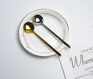 Stainless steel coffee stirring spoon set, gold and silver spoons with white saucer.