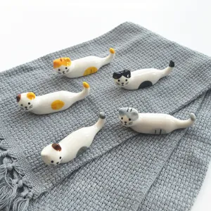 Nahaufnahme niedlicher Keramik-Katzen-Stäbchenhalter, Detailansicht mit verschiedenen süßen Mustern.