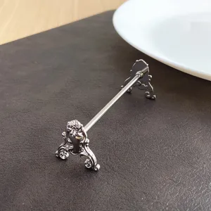 Close-up of ornate silver stainless steel cutlery rest with vintage floral carving details
