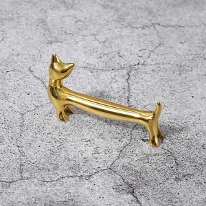 Nahaufnahme eines goldenen Dackel Metall-Essstäbchenhalters mit glänzender Oberfläche.