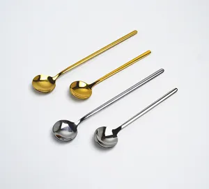 Stainless steel coffee stirring spoon detail, long handle round spoon design, gold and silver color.