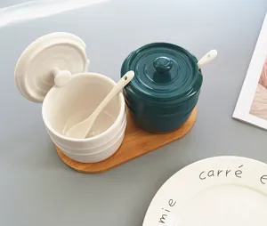 Detailansicht der Keramik-Gewürzdosen mit Löffeln auf einem eleganten Holztablett