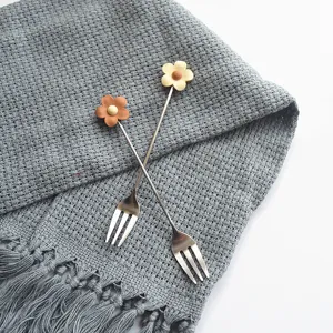 Detailed close-up shot of stainless steel fruit fork featuring cute flower handle design.