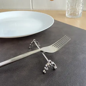 Detailed macro view of an ornate silver stainless steel fork rest with vintage carvings.