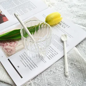 Gros plan d'une cuillère à mélanger en céramique blanche en forme de tulipe.