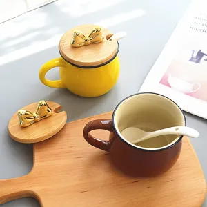 Detailed view of cute ceramic coffee mug with wooden lid, golden bow and ceramic spoon setup.