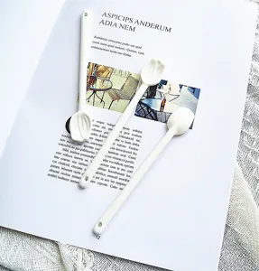 Vue détaillée de cuillères en céramique blanche en forme de tulipe sur un magazine