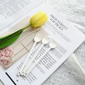 Détail de trois élégantes cuillères en céramique blanche avec têtes en forme de tulipe.