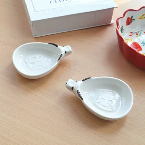 Detailed view of cute ceramic cow sauce dish, Japanese style cartoon animal flavoring dish for sushi.